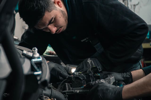 Mechanic in work gloves concentrating under the hood